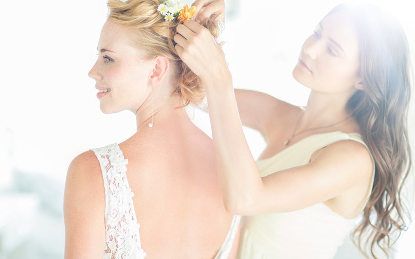 A maid of honor helps the bride get ready